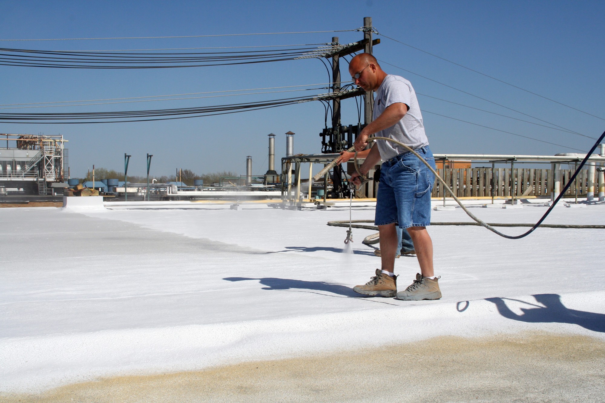 Roofer applying spray foam commercial roofing